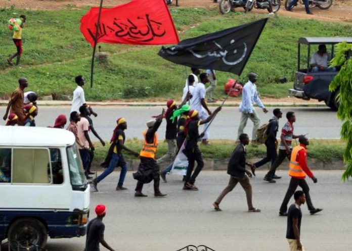 EDITORS NOTE: Graphic content / Members of Islamic Movement of Nigeria (IMN) wave flags and chant slogans as they take part in a demonstration to protest against the imprisonnement of a Shiite, in Abuja, on October 29, 2018. - The army and police confronted members of the Islamic Movement of Nigeria (IMN), the group's spokesman Ibrahim Musa told AFP, amid reports of casualties. Rights groups have accused Nigeria's military of killing more than 300 IMN supporters and burying them in mass graves during the 2015 confrontation, a charge the military strongly denies. (Photo by Sodiq ADELAKUN / AFP)