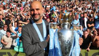 Manchester City boss Pep Guardiola holds the Premier League trophy
