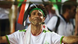 Algerian fan shows the Egyptian flag during the semi-final match against Nigeria