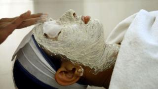 An Indian woman receives a facial at a beauty salon in New Delhi