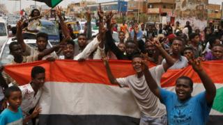 Sudanese people celebrate in the streets of Khartoum after ruling generals and protest leaders announced they had reached an agreement on the disputed issue of a new governing body on 5 July