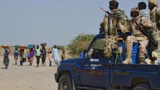 People from the Nigerian town of Malam Fatori an its area, close to the borders with Niger and Chad, pass by a car with Chadian Gendarmes (in uniform) as they flee Islamist Boko Haram attacks to take shelter in the Niger's town of Bosso secure by Niger and Chad armies, on May 25, 2015.