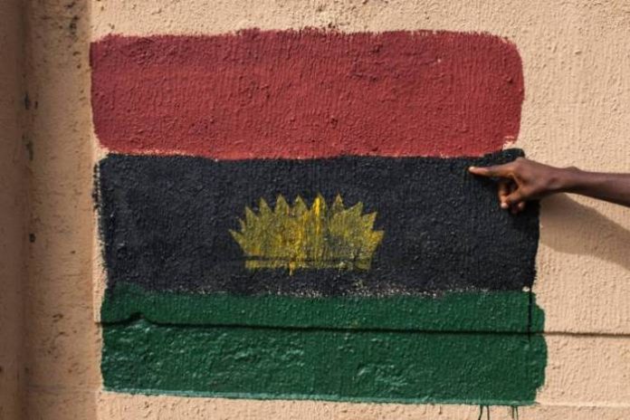 A man points at a Biafran flag painted on a wall on Old Market Road in Onitsha, Nigeria, during a shutdown in commemoration of the 50th anniversary of the Nigerian Civil War on May 30. At least 1 million people were killed in the war, started after an ex-Nigerian military officer declared an independent Republic of Biafra in 1967. STEFAN HEUNIS/AFP/GETTY